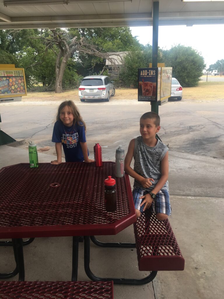 Kids waiting for dinner! The beloved van is in the background. 
